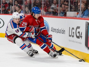 Nathan Beaulieu #28 of the Montreal Canadiens tries to protect the puck from Jesper Fast #19 of the New York Rangers during the NHL game at the Bell Centre on March 26, 2016, in Montreal.