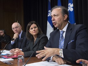 Quebec Treasury Board president, right, Sam Hamad with Quebec Transport Minister Jacques Daoust, left, and Quebec Justice Minister Stephanie Vallee during a news conference on government contracts allotment, Thursday, March 24, 2016 at the legislature in Quebec City.
