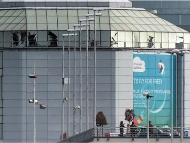 Soldiers from the Belgian Army patrol in front of broken windows at Zaventem Airport in Brussels after an explosion on Tuesday, March 22, 2016.