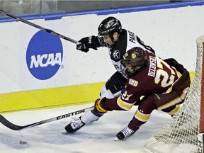 Providence defenseman Tom Parisi (6) and Minnesota-Duluth center Cal Decowski (27) chase the puck in the second period of a regional semifinal game in the NCAA college hockey tournament, Friday, March 25, 2016, in Worcester, Mass.