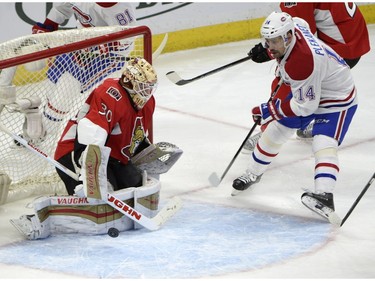 Montreal Canadiens' Tomas Plekanec (14) stops outside the crease as the puck passes Ottawa Senators' goalie Andrew Hammond (30) during second period NHL hockey action in Ottawa on Saturday, March 19, 2016.