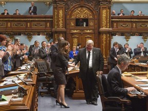 Members of the Quebec legislature applaud Veronique Hivon, left and Quebec Health minister Gaétan Barrette on Thursday, May 22, 2014 in Quebec City, the day that the Liberal government re-introduced the PQ's Bill 52.