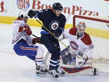 Winnipeg Jets forward Marko Dano (centre) charges the net of Montreal Canadiens goaltender Mike Condon as defenceman Mark Barberio defends in Winnipeg on Sat., March 5, 2016. Kevin King/Winnipeg Sun/Postmedia Network