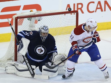 Winnipeg Jets goaltender Ondrej Pavelec and Montreal Canadiens forward Brendan Gallagher can't find a puck that flipped high in the air in Winnipeg on Sat., March 5, 2016.