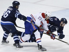 Montreal Canadiens' Alex Galchenyuk (27) collides with Winnipeg Jets' Tyler Myers (57) as Joshua Morrissey (36) defends during first period NHL action in Winnipeg on Saturday, March 5, 2016.
