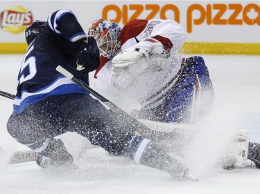 Montreal Canadiens goaltender Mike Condon (39) saves the shot by Winnipeg Jets' Mathieu Perreault (85) during second period NHL action in Winnipeg on Saturday, March 5, 2016.