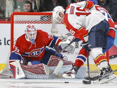 Mike Condon keeps his eyes on the puck as the Panthers' Aleksander Barkov is checked by Andrei Markov during third period in Montreal on Tuesday, April 5, 2016.