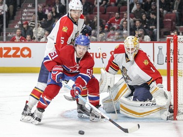 David Desharnais reaches for the puck while being checked by the Panthers' Aaron Ekblad in front of goalie Roberto Luongo during third period in Montreal on Tuesday, April 5, 2016.