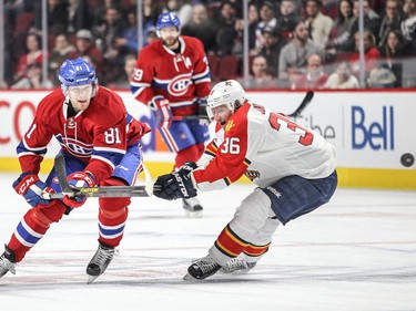 Lars Eller, left, chips the puck past Jussi Jokinen of the Florida Panthers during third period in Montreal on Tuesday, April 5, 2016.