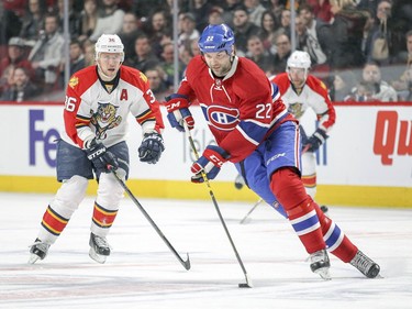 John Scott carries the puck up ice past  Panthers' Jussi Jokinen during first period in Montreal  on Tuesday April 5, 2016.