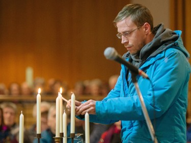 Martin Lapierre, son Laure Lapierre, lights a candle during a commemorative mass for the victims of the March 29 airplane crash at Sainte-Madeleine de Havre-aux-Maisons church in Les Iles de la Madeleine on Tuesday, April 5, 2016.