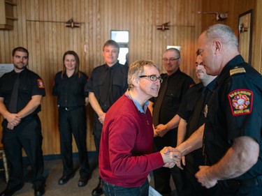 Parish priest Claude Gosselin greets firefighters before a special commemorative mass in memory of the seven airplane crash victims at the Sainte-Madeleine de Havre-aux-Maisons church in Les Iles de la Madeleine on Tuesday, April 5, 2016.