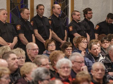 Firefighters and community members listen to a commemorative mass for the victims  of the March 29 airplane crash at Sainte-Madeleine de Havre-aux-Maisons church in Les Iles de la Madeleine on Tuesday, April 5, 2016.