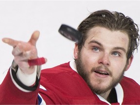 Canadiens' Alex Galchenyuk throws a puck to fans following the Canadiens win over the Tampa Bay Lightning in an NHL hockey game in Montreal, Saturday, April 9, 2016.