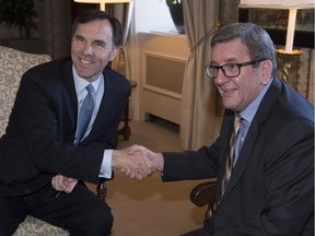 Finance Minister Bill Morneau, left, is greeted by Quebec City mayor Régis Labeaume, Friday, April 29, 2016 at city hall in Quebec City.