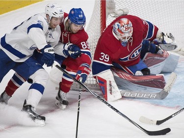 Tampa Bay Lightning's Braydon Coburn (55) moves in on Montreal Canadiens goaltender Mike Condon as Canadiens' Ryan Johnston (89) defends during second period NHL hockey action in Montreal, Saturday, April 9, 2016.