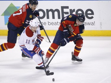 Florida Panthers center Nick Bjugstad (27) and right wing Reilly Smith (18) battle for the puck with Montreal Canadiens right wing Brendan Gallagher (11) during the first period of an NHL hockey game, Saturday, April 2, 2016, in Sunrise, Fla.
