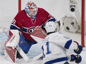 Canadiens goaltender Mike Condon makes a save against Tampa Bay Lightning's Brian Boyle during first period NHL hockey action in Montreal, Saturday, April 9, 2016.
