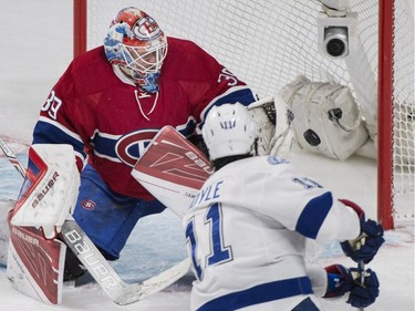 Montreal Canadiens goaltender Mike Condon makes a save against Tampa Bay Lightning's Brian Boyle during first period NHL hockey action in Montreal, Saturday, April 9, 2016.