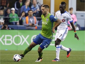 Seattle Sounders forward Clint Dempsey, left, drives around Montreal Impact's Dominic Oduro during the first half of an MLS soccer match, Saturday, April 2, 2016, in Seattle. The Sounders won 1-0.