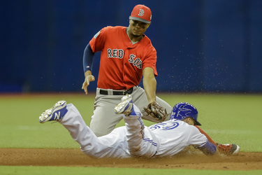 Toronto Blue Jays second baseman Jon Berti steals second base against Boston Red Sox infielder Xander Bogaerts during the sixth inning of their exhibition game at the Olympic Stadium in Montreal on Friday, April 1, 2016.