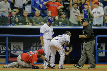 Toronto Blue Jays center fielder Roemon Fields, centre, is called out by the third base umpire as Boston Red Sox first baseman Travis Shaw, left, shows the position of his glove during the ninth inning of their exhibition game at the Olympic Stadium in Montreal on Friday, April 1, 2016.