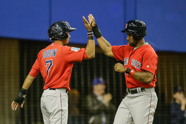 Boston Red Sox infielder Mauricio Dubon, left, and teammate Chris Young, right, celebrate their runs during their exhibition game at the Olympic Stadium in Montreal on Friday, April 1, 2016.