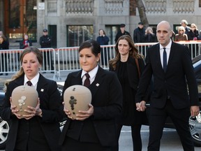 Jean Lapierre's daughter Marie-Anne Lapierre, rear left, and her spouse Mathieu Belhumeur, rear right, follow the urns as they arrive for the second funeral of former MP and media personality Jean Lapierre and his wife Nicole Beaulieu at St-Viateur-d'Outremont church in Montreal on Saturday, April 16, 2016.