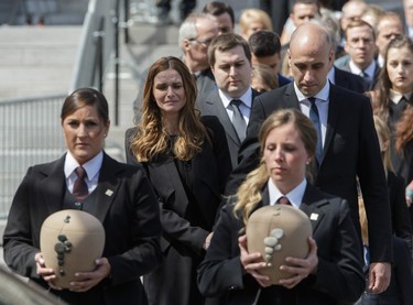 Children of former MP and media personality Jean Lapierre, Marie-Anne Lapierre, second from left, and her brother Jean Michel Lapierre, third from left, and Marie-Anne's spouse Mathieu Belhumeur, right, follow the urns carrying the remains of Jean Lapierre and his wife Nicole Beaulieu at the end of their funeral at Saint-Viateur-d'Outremont church in Montrealon Saturday, April 16, 2016. The couple died on March 29 in an airplane crash along with Lapierre’s siblings Louis Lapierre, Marc Lapierre, and Martine Lapierre as well as pilots Pascal Gosselin and Fabrice Labourel. The group was heading to Les Iles-de-la-Madeleine for the funeral of their father Raymond Lapierre.