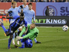 Impact's Dominic Oduro, left, scores tying goal past helpless New York City FC goalkeeper Josh Saunders (12) during stoppage time in the second half Wednesday, April 27, 2016, at Yankee Stadium in New York.