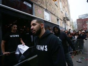 Toronto rapper Drake leaves a Queen St. West pop up shop where he was handing out T-shirts to promote his upcoming album in Toronto on Sunday, April 24, 2016.
