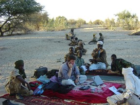 From the documentary A la poursuite de la paix (In Pursit of Peace). Andrew Marshall, holding telephone, acting as mediator of armed conflict with Darfur rebels.  Photo credit Andrew Marshall.