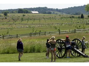 In this  June 5, 2013 file photo tourist gather near a Confederate artillery piece that sit atop a ridge above the field of Pickett's Charge, in Gettysburg, Pa.  As the 150th anniversary of the Battle of Gettysburg draws near the character and historic legacy of the town remain divided as hundreds of thousands of tourists visit the battlefield where so many died and development continues unabated around the site, drawing outlet shopping, restaurants and a casino.