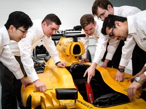 Infiniti Engineering Academy students look over a Formula One Renault racer.