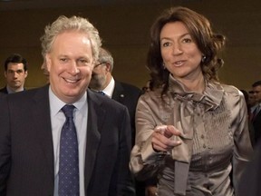 Quebec Premier Jean Charest smiles as he arrives with Quebec Natural Resources Minister Nathalie Normandeau to unveil the Quebec government's 2011-2020 action plan for electric vehicles in Quebec City, Thursday April 7, 2011. Former Quebec premier Charest says he has full confidence in ex-deputy premier Normandeau as she faces corruption-related charges.