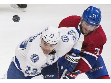 Montreal Canadiens' Joel Hanley (71) and Tampa Bay Lightning's J.T. Brown (23) battle for the puck during second-period NHL hockey game action in Montreal, Saturday, April 9, 2016.