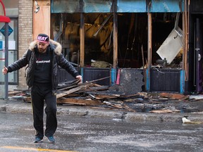 Jonathan Domer, manager at the Candi Bar on Mont Royal, walks away from the burnt out remains of the bar following a fire, Monday April 4, 2016.  The cause of the fire is being investigated.