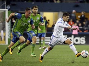 Montreal Impact forward Lucas Ontivero, right, teaks a shot as Seattle Sounders defender Dylan Remick, left, and midfielder Andreas Ivanschitz pursue during the first half of an MLS soccer match, Saturday, April 2, 2016, in Seattle.
