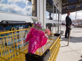 Manager Steve Mathieu stands outside the Maxi store at Papineau and Crémazie, where bouquets of flowers rest in a shopping cart, April 12, 2016, a day after an employee was stabbed to death.