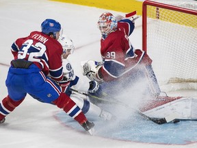 Tampa Bay Lightning's Mike Blunden slides in on Montreal Canadiens goaltender Mike Condon as Canadiens' Brian Flynn defends during third period NHL hockey action in Montreal, Saturday, April 9, 2016.