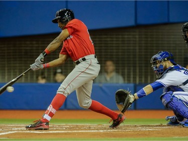 Boston Red Sox left fielder Chris Young, left, strikes out as Toronto Blue Jays catcher Russell Martin, right, anticipates the ball during the first inning of their exhibition game at the Olympic Stadium in Montreal on Friday, April 1, 2016.