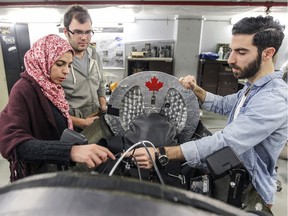Team coordinator Rim Hamila, left, talks with technical director Derek Greenblatt and team consultant Norvan Ghazabegi, right, about modifications to the steering mechanism on Concordia University's entry in this year's Shell Ecomarathon, in Montreal Monday April 11, 2016. (John Mahoney} / MONTREAL GAZETTE)