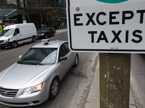 In this file photo from April 18, a taxi drives on Rene-Levesque boulevard on the corner of Peel St. After threatening to withhold taxes to pressure the provincial government to deal with Uber, Montreal taxi drivers are now threatening a "very hot" summer unless a law essentially eliminating Uber isn't adopted by this Friday.