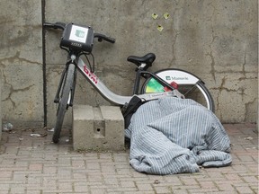 A person rests under a comforter at Viger Park.