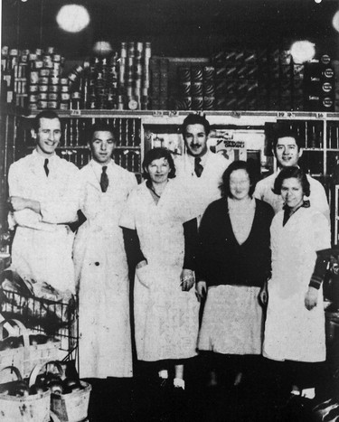 A 1920s group portrait of employees in the interior of the original Steinberg grocery store at 4419 St-Laurent Blvd. Owner Ida Steinberg, not visible in the photo, is standing behind the cash off to the side of the group. The store, founded in 1917, went on to become Steinberg's, Quebec's largest supermarket chain for many years. Source: Jewish Public Library Archives.