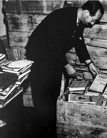 Rabbi Lavy Becker with European Jewish literature recovered from Germany, 1946. This photo was probably taken in Montreal. Becker, a rabbi and a social worker, served as director of displaced persons camps in Germany for the Joint Distribution Committee. Source: Alex Dworkin Canadian Jewish Archives.