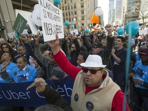 Mohamad Aboualkhir, front, joins Uber drivers and supporters at a demonstration in support of the service in downtown Montreal, Friday April 29, 2016.