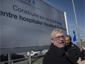 Quebec Health Minister Gaetan Barrette stands in front of the sign announcing a planned new hospital in the Vaudreuil-Soulanges region. The hospital will be located at Highway 30 and Cité-des-Jeunes Blvd. in Vaudreuil-Dorion, Monday, April 4, 2016. (Peter McCabe / MONTREAL GAZETTE)