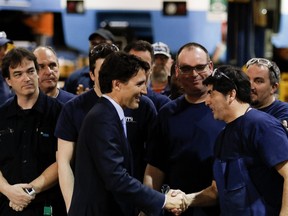 Justin Trudeau, Prime Minister of Canada, speaks with employees during a visit at the Hangar d'Youville STM repair centre in Montreal on Wednesday April 6, 2016. (Allen McInnis / MONTREAL GAZETTE)