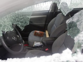 A brick sits on the passenger seat of a vandalized car on Pascal St. in Montreal North, Thursday April 7, 2016.  A small riot following a peaceful demonstration resulted in torched and vandalized cars, vandalized buildings including a police station.